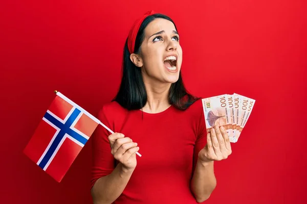 Молода Іспаномовна Жінка Тримає Прапор Норвегії Банкноти Крони Сердитий Божевільний — стокове фото