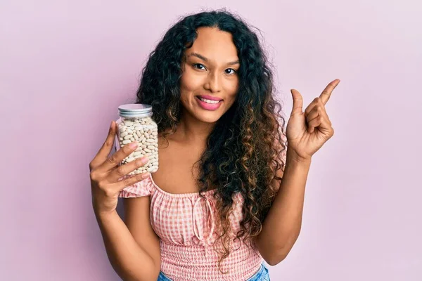 Jovem Latina Segurando Jarra Feijão Sorrindo Feliz Apontando Com Mão — Fotografia de Stock