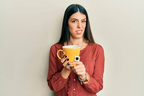 Молода Іспаномовна Жінка Тримає Чашку Чаю Безглуздим Заплутаним Виразом Концепція — стокове фото