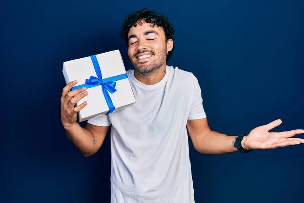 Молодий Іспаномовний Чоловік Тримає Подарунок Святкуючи Досягнення Щасливою Посмішкою Виразом — стокове фото