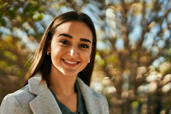 Genç İspanyol kız parkta mutlu bir şekilde gülümsüyor..
