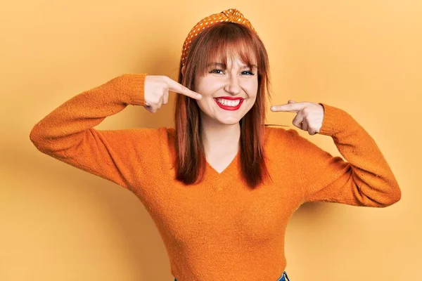 红头发的年轻女人穿着休闲的橙色毛衣 笑容满面 用手指 牙齿和嘴指尖 牙齿健康概念 — 图库照片
