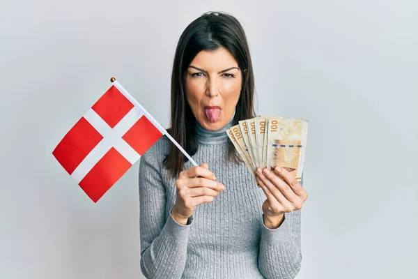 Young Hispanic Woman Holding Danmark Flag Krone Banknotes Sticking Tongue — Stock Photo, Image