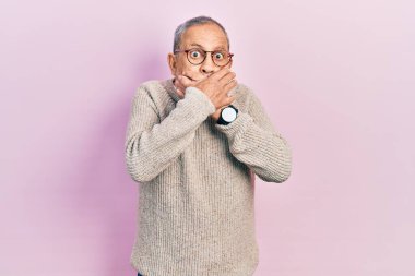 Sakallı, sıradan süveter giyen ve gözlüklü yakışıklı bir adam ağzını yanlışlıkla elleriyle kapatmış. gizli kavram. 