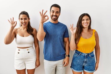 İzole edilmiş arka planda durup gülümseyen bir grup İspanyol el ve parmaklarıyla 