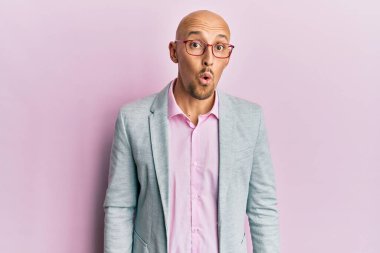 Sakallı, iş kıyafetleri ve gözlüklü, ağzı açık, korkmuş ve hayrete düşmüş kel bir adam. 