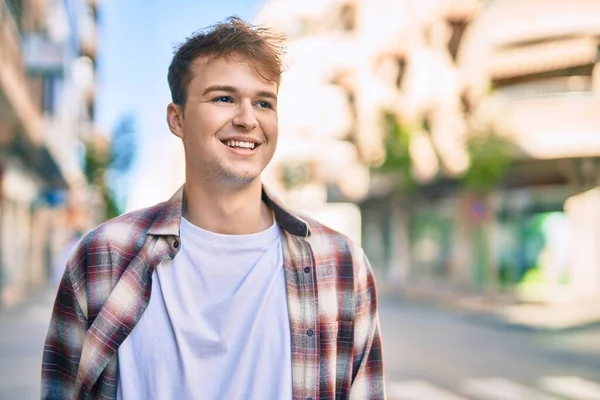 若い白人男性が幸せそうに街に立って笑っている — ストック写真