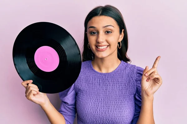 Ung Latinamerikansk Kvinna Håller Vinylskiva Leende Glad Pekar Med Hand — Stockfoto