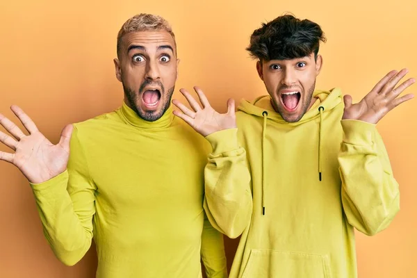 Гомосексуальная Гей Пара Стоящая Вместе Жёлтой Одежде Празднуя Безумие Удивляясь — стоковое фото