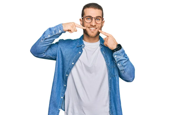 カジュアルな服装をした若い白人男性が陽気で 指の歯と口を指差して微笑んだ 歯の健康の概念 — ストック写真