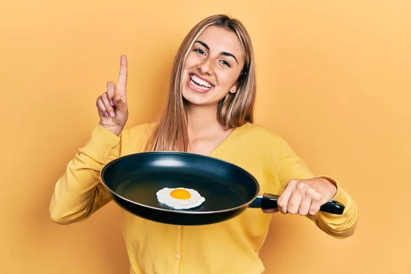 Красива Іспаномовна Жінка Готує Смажене Яйце Посміхаючись Ідеєю Або Питанням — стокове фото