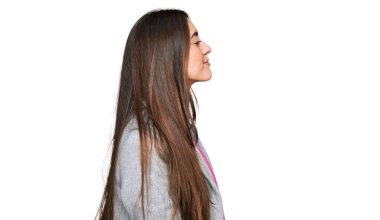 Latin kökenli genç bir kız iş kıyafetleri giyiyor. Tarafını arıyor. Profil pozu veriyor.. 