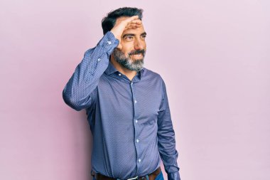 Orta yaşlı, sakallı, gri saçlı, iş elbiseleri giyen mutlu ve tebessüm eden bir adam. arama kavramı. 