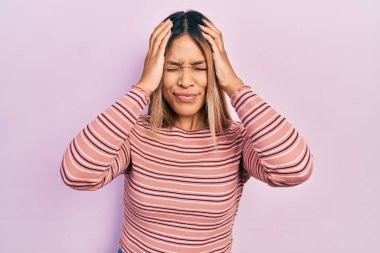 Güzel İspanyol kadın gündelik çizgili kazak giyiyor. Baş ağrısı çekiyor, çaresiz ve stresli. Ağrı ve migren yüzünden. Eller başının üstünde.. 