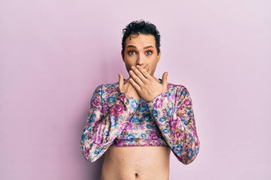 Moda kıyafetleri giyen yakışıklı bir adam yanlışlıkla elleriyle ağzını kapatırken şok oldu. gizli kavram. 