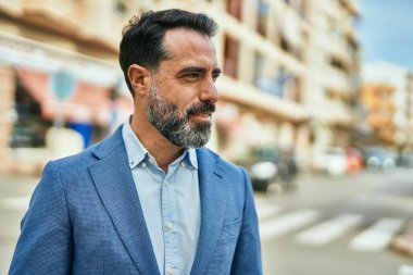 Orta yaşlı işadamı şehirde mutlu mesut dikilirken.