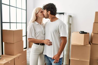 Genç ve güzel çift yeni evlerinde öpüşüyor ve sarılıyorlar..