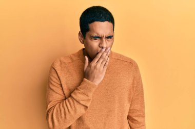 Sıradan bir kazak giyen genç, yakışıklı İspanyol adam ağzıyla ağzını kapatmaktan sıkılmış. Huzursuz ve uykulu.. 