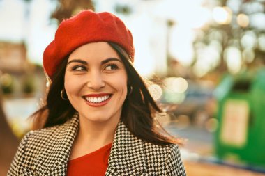 Genç İspanyol kadın gülümseyerek şehirde mutlu mesut dikiliyor..