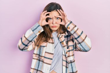 Gündelik kıyafetler giyen genç beyaz kız parmaklarıyla gözlerini açmaya çalışıyor, uykulu ve yorgun sabah yorgunluğu çekiyor. 