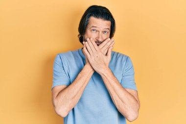 Sıradan kıyafetler giyen orta yaşlı beyaz bir adam yanlışlıkla elleri ile ağzını kapatırken şok oldu. gizli kavram. 