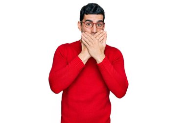 Sıradan kıyafetler ve gözlük takan yakışıklı İspanyol adam yanlışlıkla ağzı ellerle kapatmış. gizli kavram. 