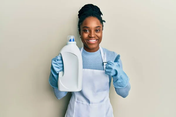 Mujer Afroamericana Con Cabello Trenzado Sosteniendo Botella Detergente Sonriendo Feliz —  Fotos de Stock