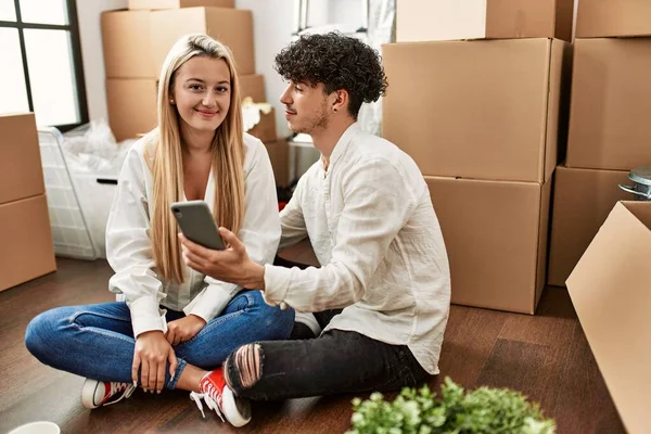 Joven Hermosa Pareja Sonriendo Feliz Con Teléfono Inteligente Nuevo Hogar — Foto de Stock