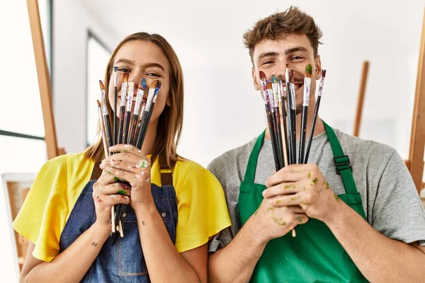 Jovem Artista Hispânico Casal Sorrindo Feliz Cobrindo Boca Com Pincéis — Fotografia de Stock