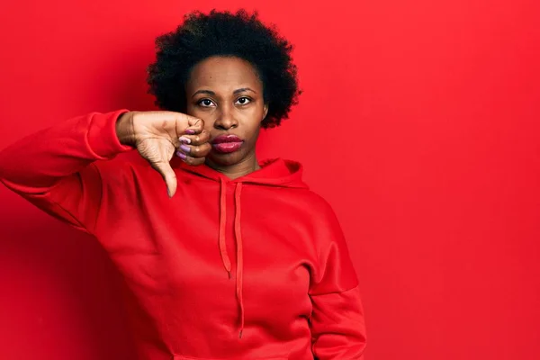 若いアフリカ系アメリカ人女性は 親指の下のジェスチャーで拒絶と否定を示す不満と怒りを見てカジュアルなスウェットシャツを着ています 悪い表現 — ストック写真
