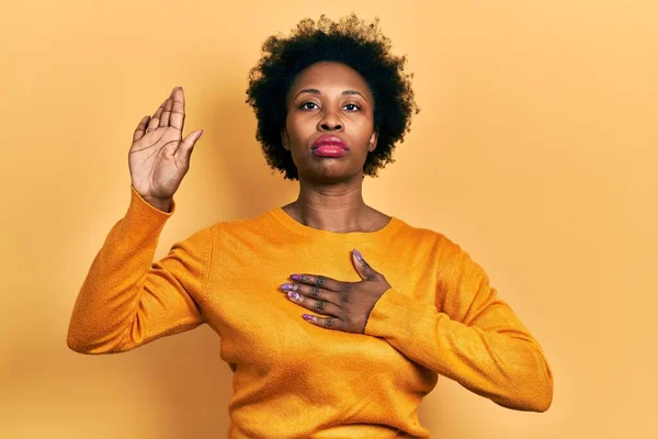 胸と手のひらに手で身に着けているカジュアルな服を身に着けている若いアフリカ系アメリカ人女性 忠誠の誓いを作る — ストック写真