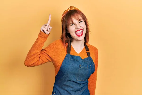 Redhead Ung Kvinna Bär Förkläde Peka Finger Upp Med Framgångsrik — Stockfoto