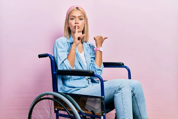 Красивая Блондинка Сидящая Инвалидном Кресле Просящая Помолчать Пальцем Губах Указывая — стоковое фото