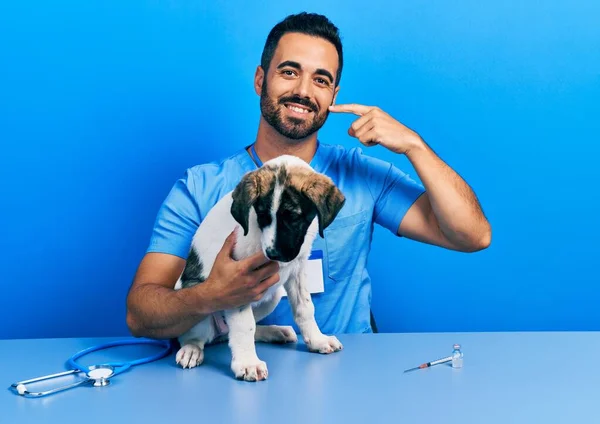 Красивый Латиноамериканец Ветеринар Бородой Проверяет Здоровье Собаки Весело Улыбаясь Показывая — стоковое фото