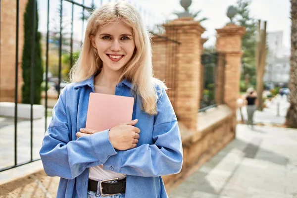 Hermosa Rubia Joven Sonriendo Feliz Celebración Libro Campus Universitario Día — Foto de Stock