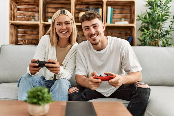 Young Caucasian Couple Smiling Happy Playing Video Game Home — ストック写真