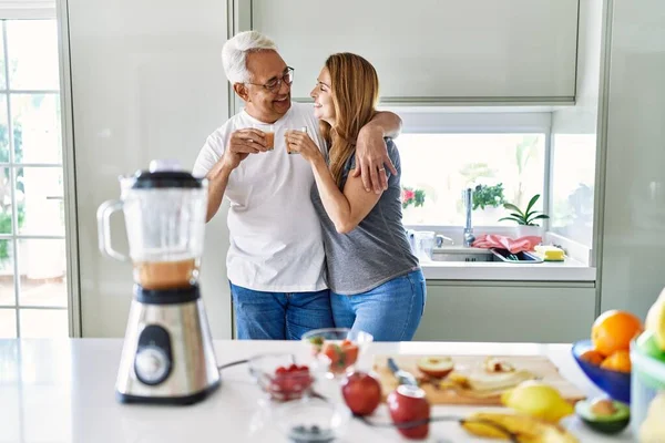 Pareja Hispana Mediana Edad Sonriendo Feliz Abrazando Vaso Batido Cocina —  Fotos de Stock