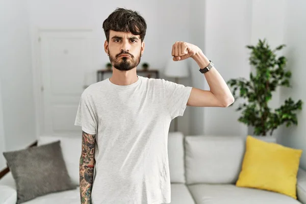 Hispanic Man Med Skägg Vardagsrummet Hemma Stark Person Visar Arm — Stockfoto