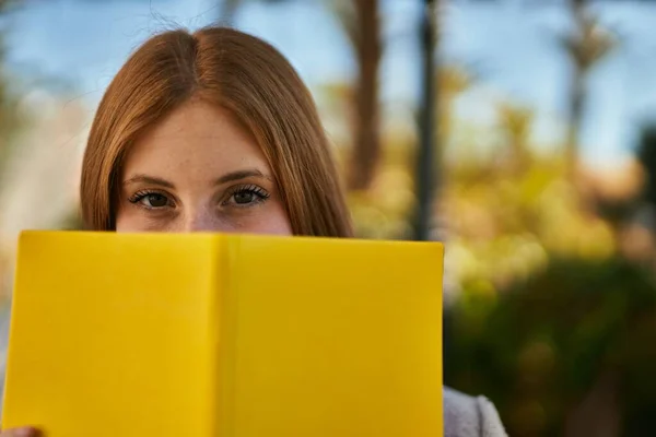 Jovem Ruiva Sorrindo Feliz Rosto Cobertura Com Livro Cidade — Fotografia de Stock