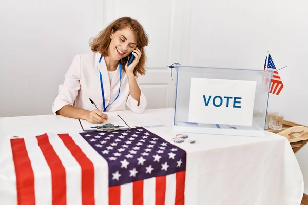 若いアメリカの政党の労働者は 選挙大学でスマートフォンで幸せな話を笑っている — ストック写真