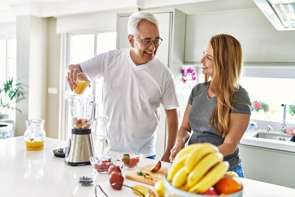 Pareja Hispana Mediana Edad Vertiendo Jugo Batido Cocina Máquina Mezcladora —  Fotos de Stock