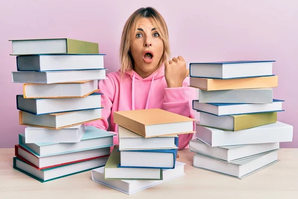 Jovem Caucasiana Sentada Mesa Com Livros Surpresos Apontando Com Dedo — Fotografia de Stock