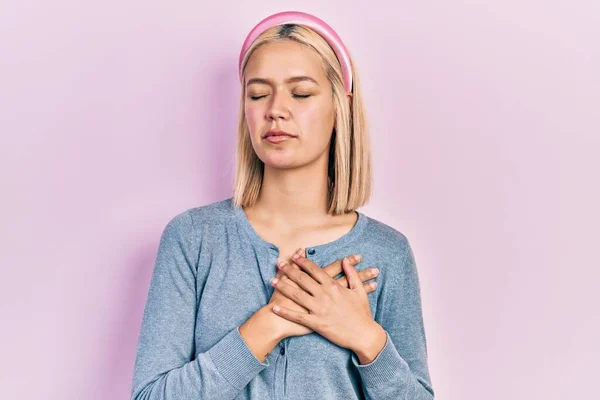 Mooie Blonde Vrouw Staat Roze Achtergrond Glimlachend Met Handen Borst — Stockfoto