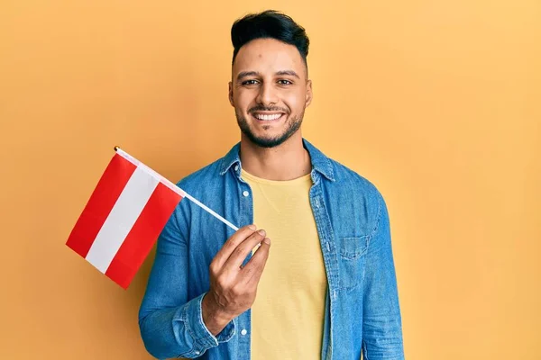 Ung Arabisk Man Håller Strutsflagga Ser Positiv Och Glad Stående — Stockfoto