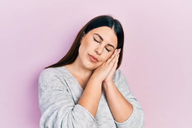 Latin kökenli genç bir kadın gündelik kıyafetler giyip uyuyordu. Yorgun düşler görüyordu. Elleriyle poz veriyordu.. 