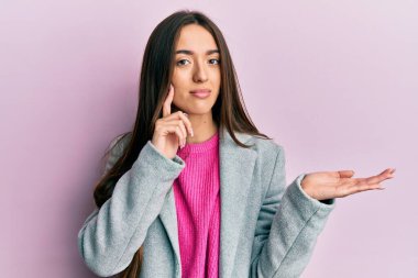 Avuç içleri açık, yüzünde ciddi bir ifadeyle gevşemiş bir şey tutan İspanyol bir kız. Basit ve doğal bir şekilde kameraya bakıyorsun.. 