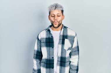 Modern boyalı saçlı, gündelik tişörtlü dudaklı, çılgın ve komik yüzlü İspanyol bir genç. Komik ifade. 