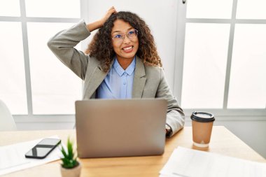 Ofisteki masasında oturan güzel İspanyol iş kadını laptopla çalışıyor ve soru sormayı merak ediyor. Şüpheyle kararsız, kafa kafaya düşünerek. Düşünceli kavram. 