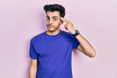 Gündelik tişört giyen genç İspanyol adam kendini vuruyor ve öldürüyor. Eli ve parmağı silah gibi kullanıyor. İntihar jesti.. 