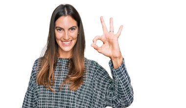 Gündelik kıyafetler giyen, gülümseyen genç ve güzel bir kadın el ve parmaklarıyla 